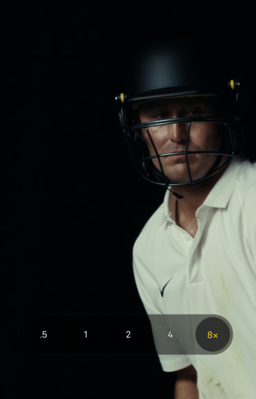 Zoomed-in close-up of cricketer Marnus Labuschagne wearing a cricket helmet and white shirt against a black background. Zoom slider is set to 8x, demonstrating clear definition at any zoom range.