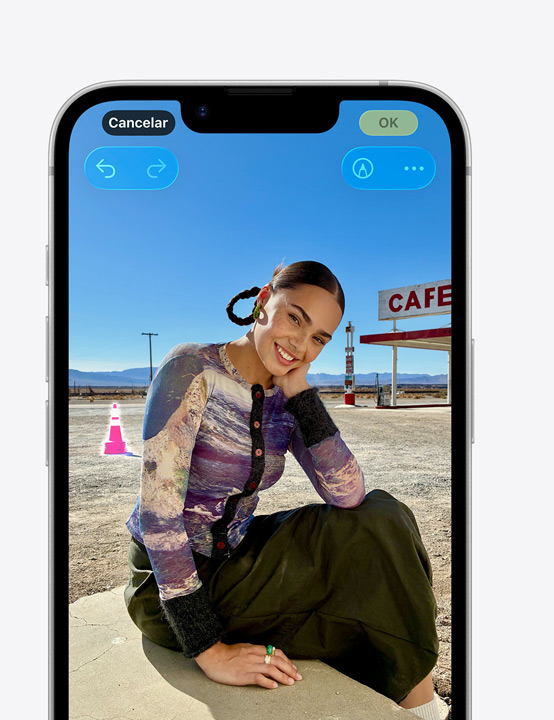 Pantalla de un iPhone, foto de una persona sonriente en la playa, eliminación de un cono en el fondo con la herramienta Limpiar