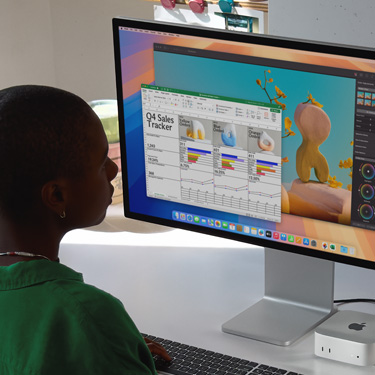 En kvinna sitter vid ett bord och arbetar med ett Excel-kalkylblad på en Mac. Kalkylbladet innehåller fjärde kvartalets försäljningssiffror. Bakom Excel-fönstret syns ett Pixelmator Pro-fönster.