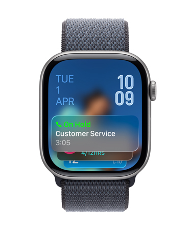 Apple Watch in Space Gray with Sage strap, Face shows Hold assist notification at bottom, date on top left, time numerals stacked at top right