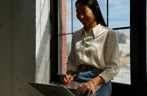 Apple Store employee standing next to a customer, both interacting with a MacBook.