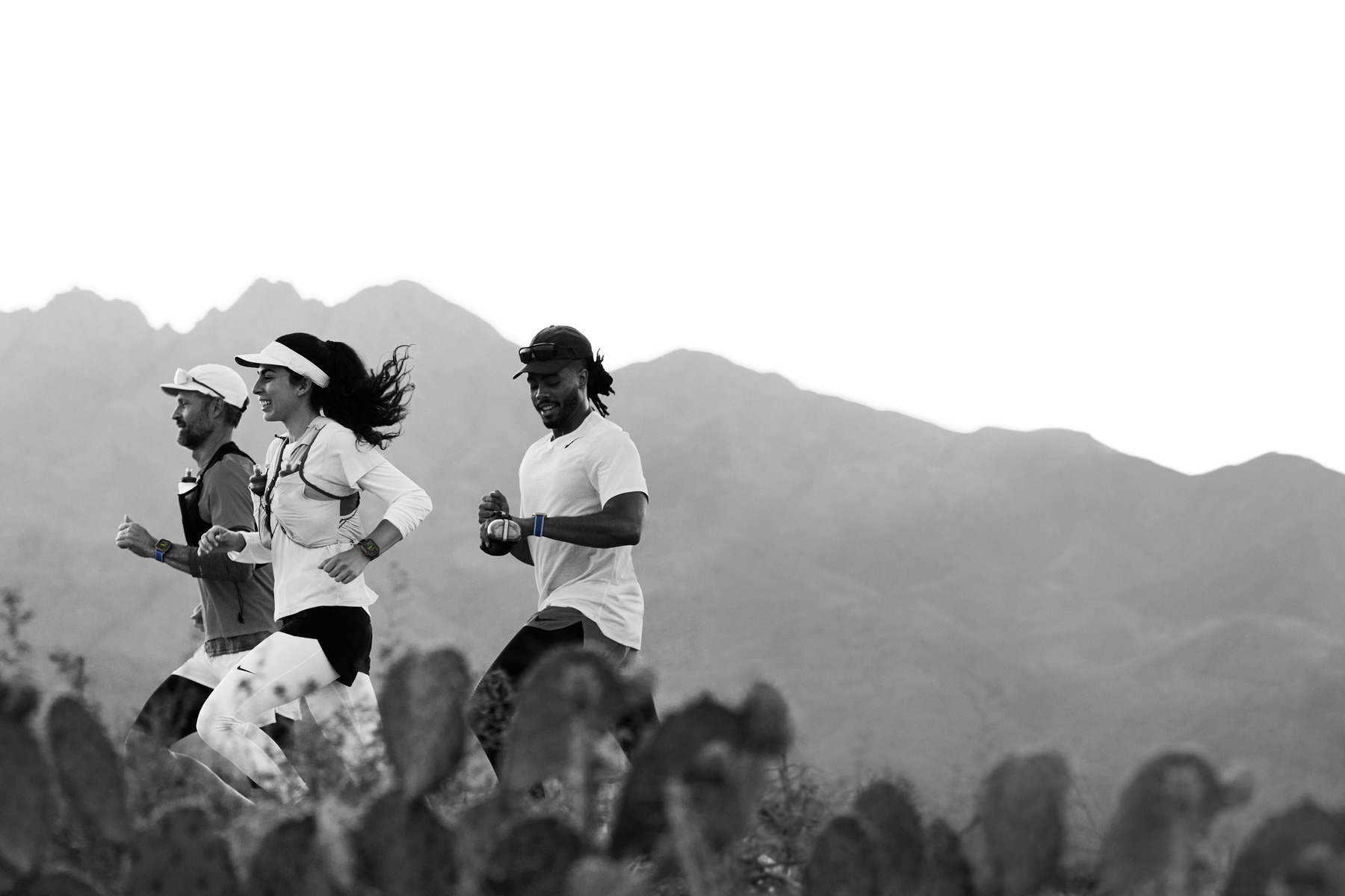 Varias personas corren por una pista en el desierto y registran sus entrenamientos en un Apple Watch Ultra 3.