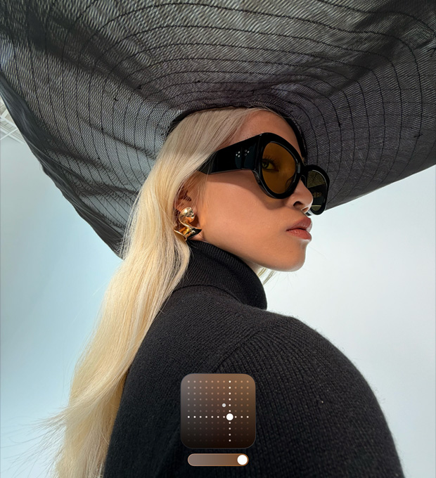 Portrét ženy v čiernom klobúku so širokou strieškou demonštruje Jasný fotografický štýl, ktorý rozjasňuje fotky nasnímané pri slabom svetle alebo v Nočnom režime